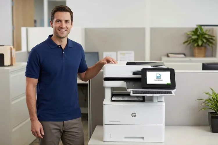 Technician standing beside a repaired HP LaserJet Enterprise MFP M528 in an office